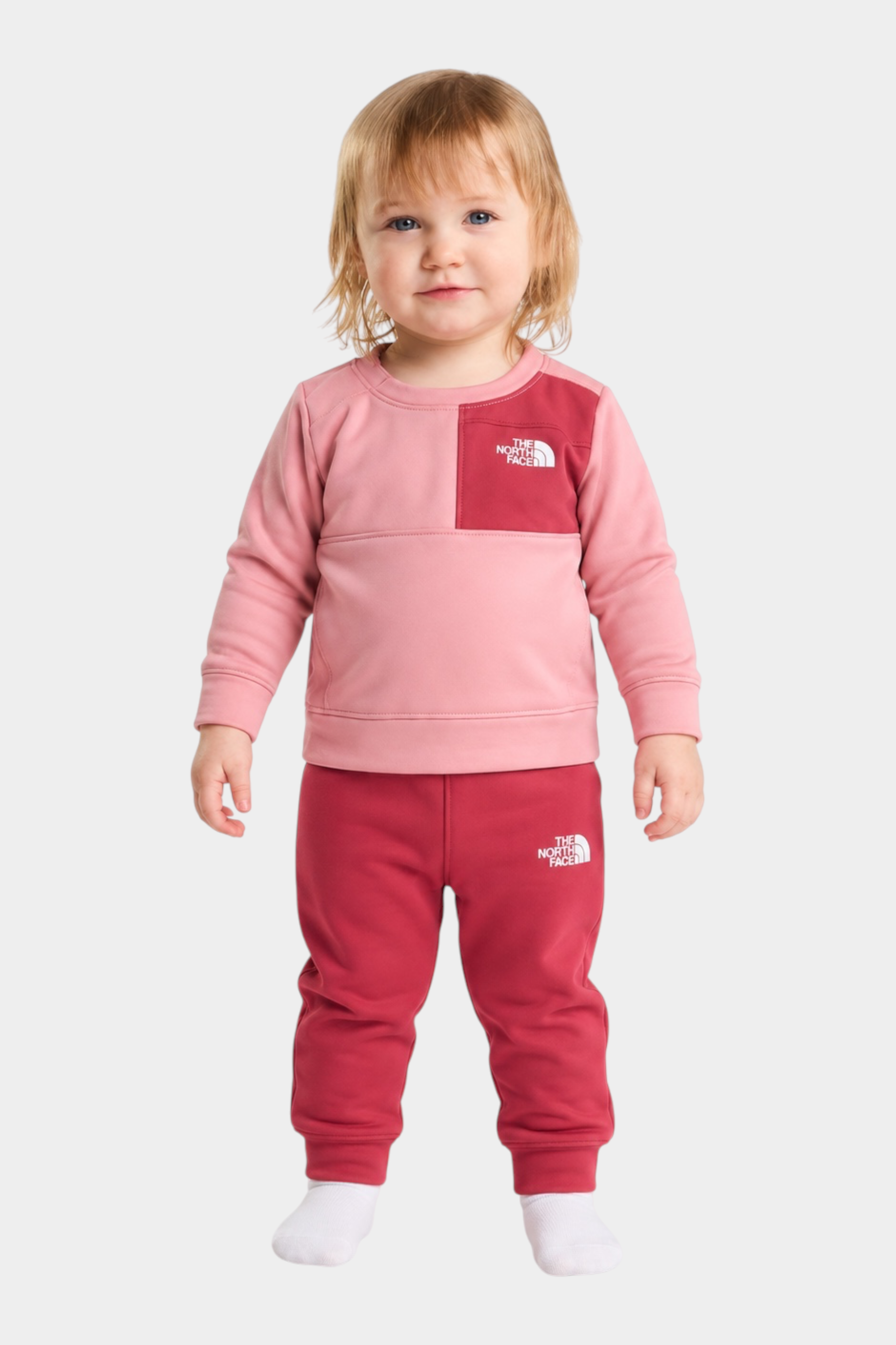 Bambina indossa completo due pezzi Follower SRL THE NORTH FACE rosa e rosso con felpa e pantaloni sportivi