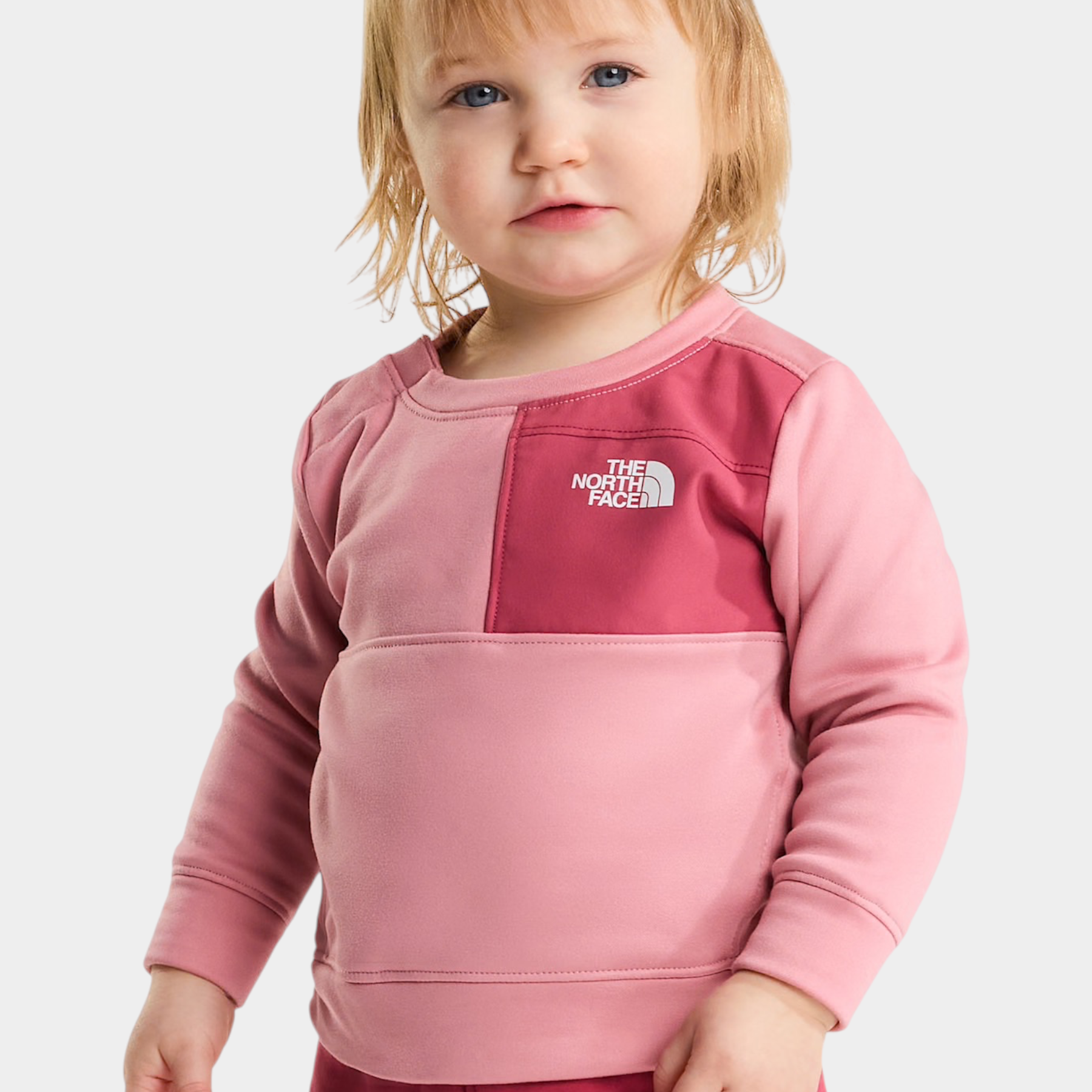 Bambina che indossa un completo due pezzi rosa THE NORTH FACE di Follower SRL con felpa a blocchi di colore
