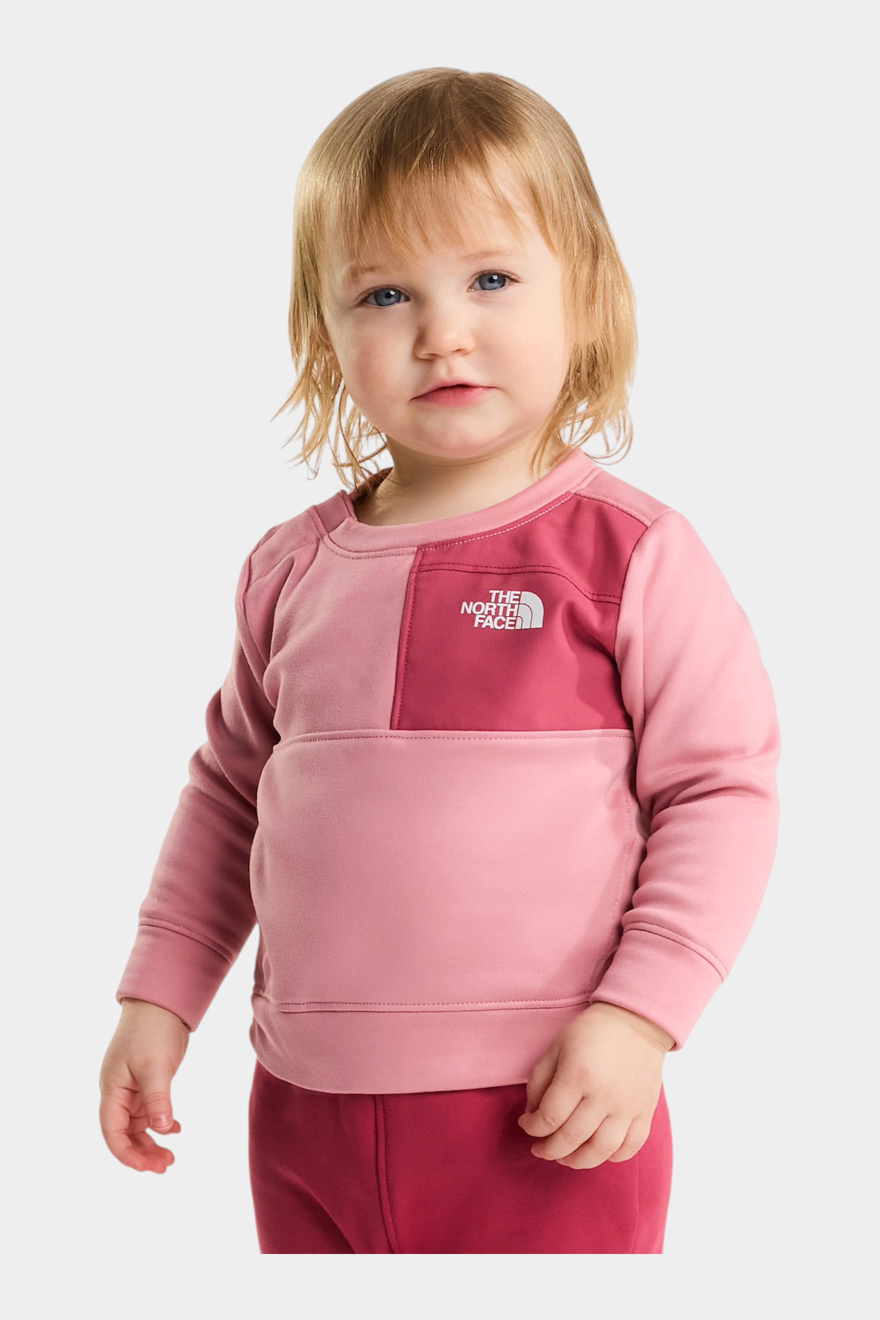 Bambina che indossa un completo due pezzi rosa THE NORTH FACE di Follower SRL con felpa a blocchi di colore