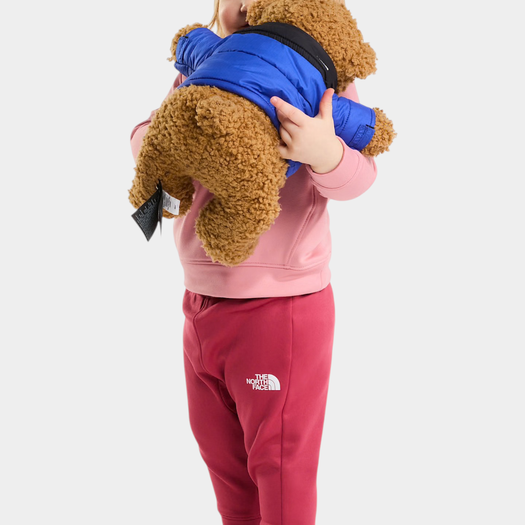 Bambina che indossa un completo Follower SRL THE NORTH FACE rosa composto da felpa e pantaloni con orsacchiotto