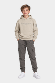 Ragazzo indossa completo Follower SRL beige con felpa con cappuccio US GRAND POLO e pantaloni cargo grigi