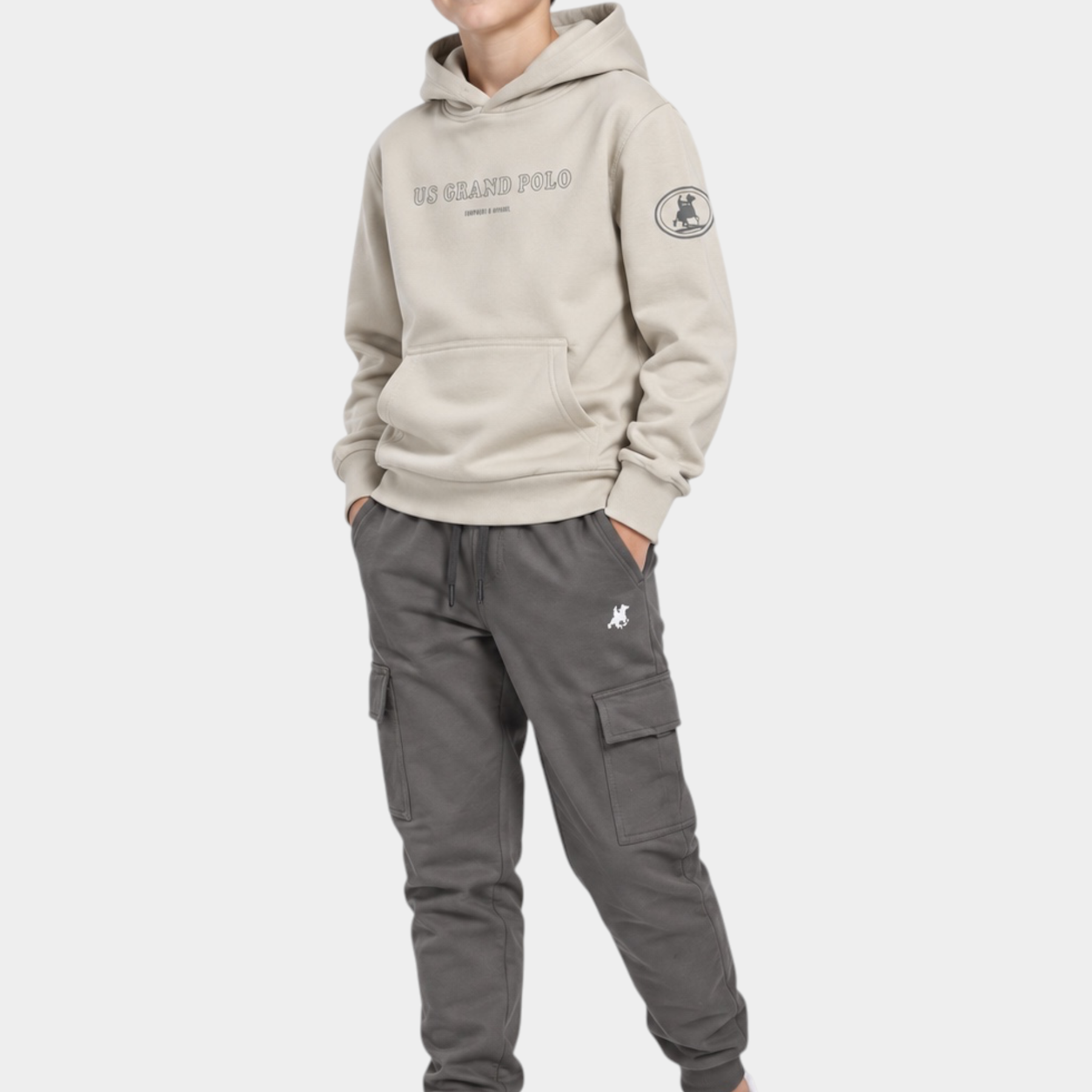 Ragazzo indossa completo Follower SRL beige con felpa con cappuccio e pantaloni cargo grigi con logo iconico
