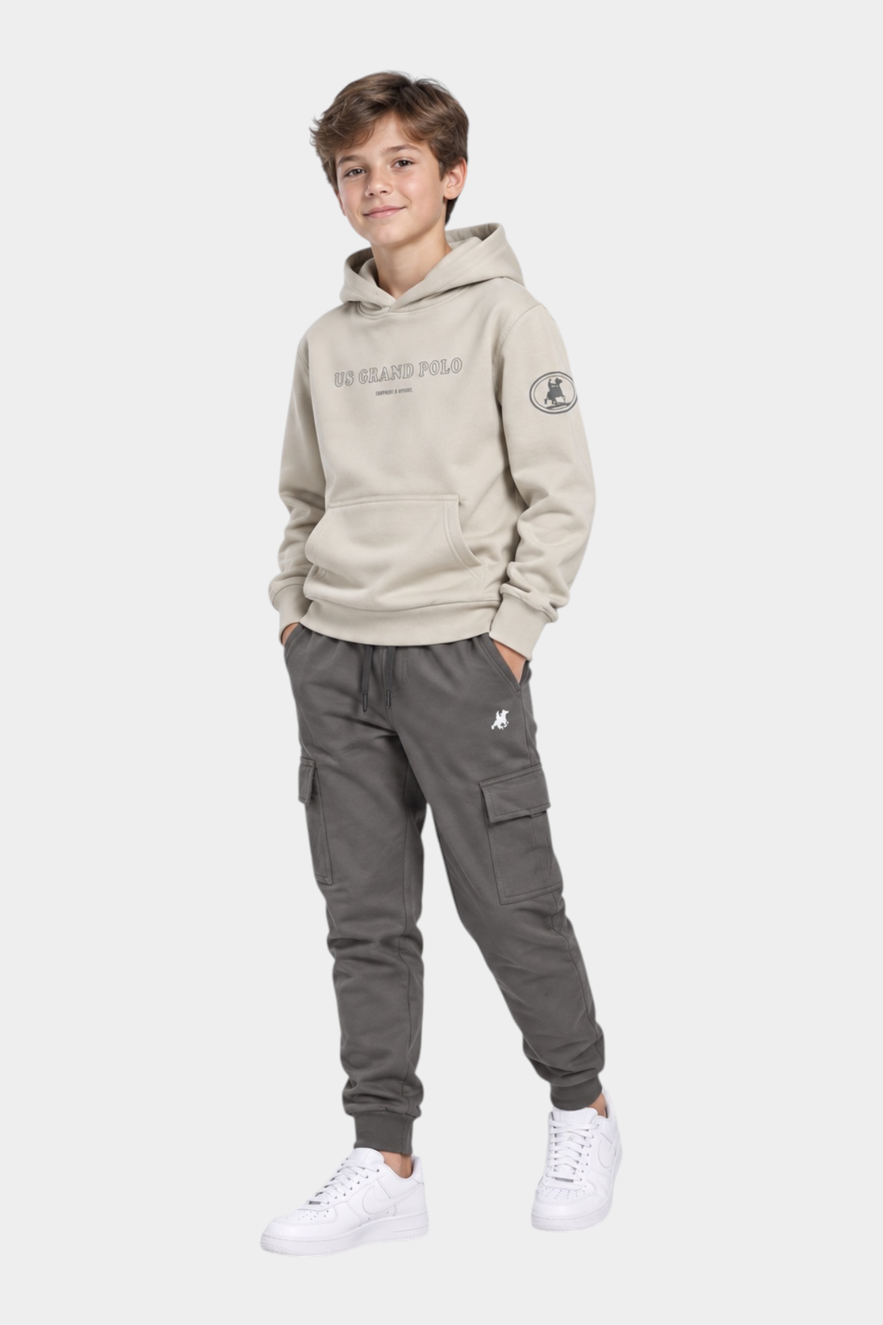 Ragazzo indossa completo Follower SRL beige con felpa con cappuccio e pantaloni cargo grigi con logo iconico