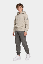 Ragazzo indossa completo Follower SRL con felpa beige con cappuccio US GRAND POLO e pantaloni cargo grigi