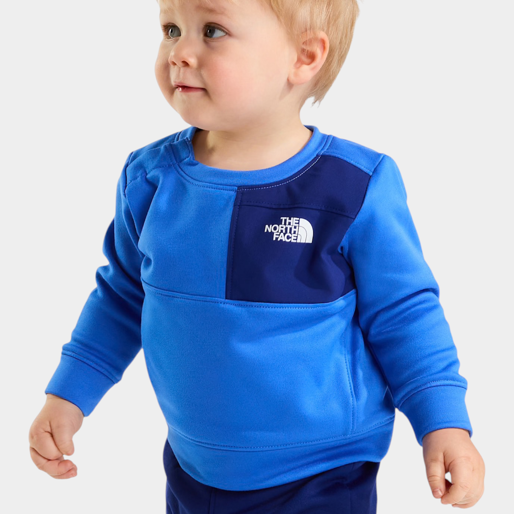 Bambino indossa completo due pezzi blu Follower SRL con logo The North Face su felpa e pantaloni