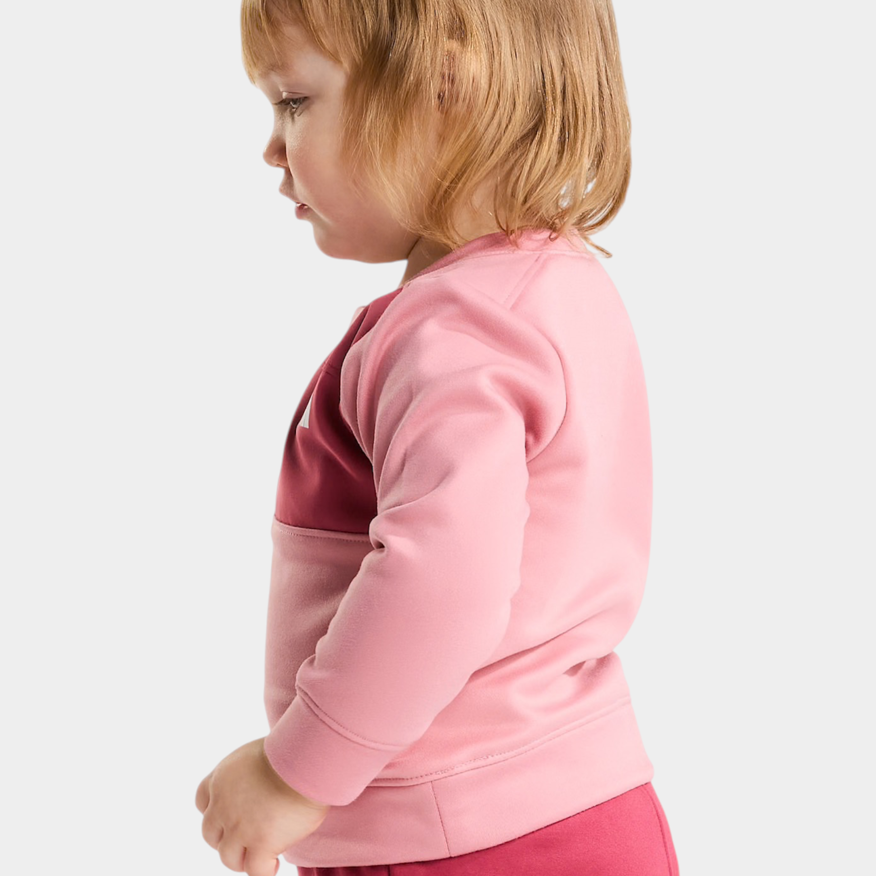 Bambina che indossa un completo due pezzi rosa THE NORTH FACE di Follower SRL, vista di profilo