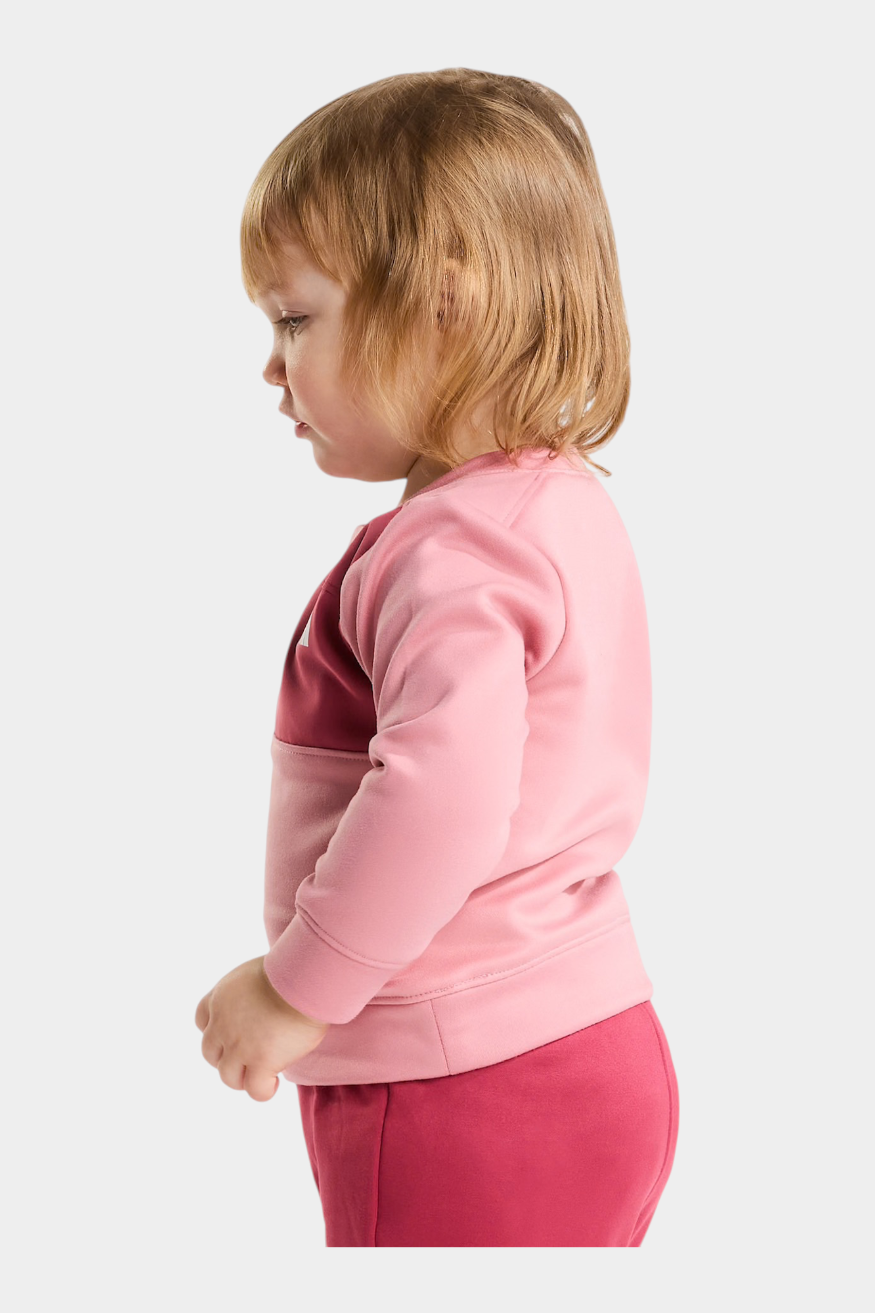 Bambina che indossa un completo due pezzi rosa THE NORTH FACE di Follower SRL, vista di profilo