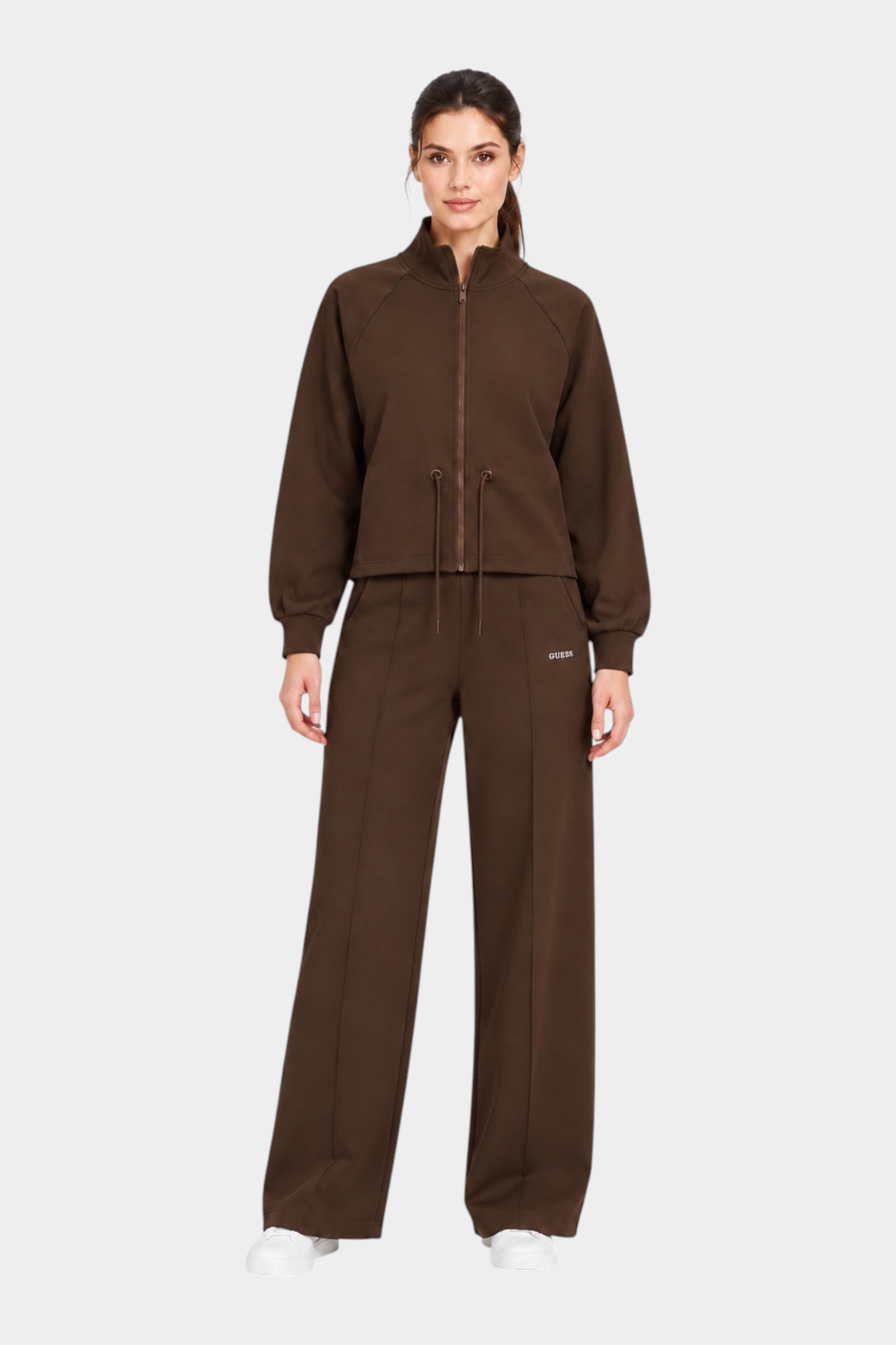 Modella indossa un completo Follower SRL marrone composto da giacca con zip e pantaloni jogger a gamba larga