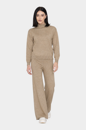 Modella indossa un completo Follower SRL beige con maglione a collo alto e pantaloni a gamba larga in maglia