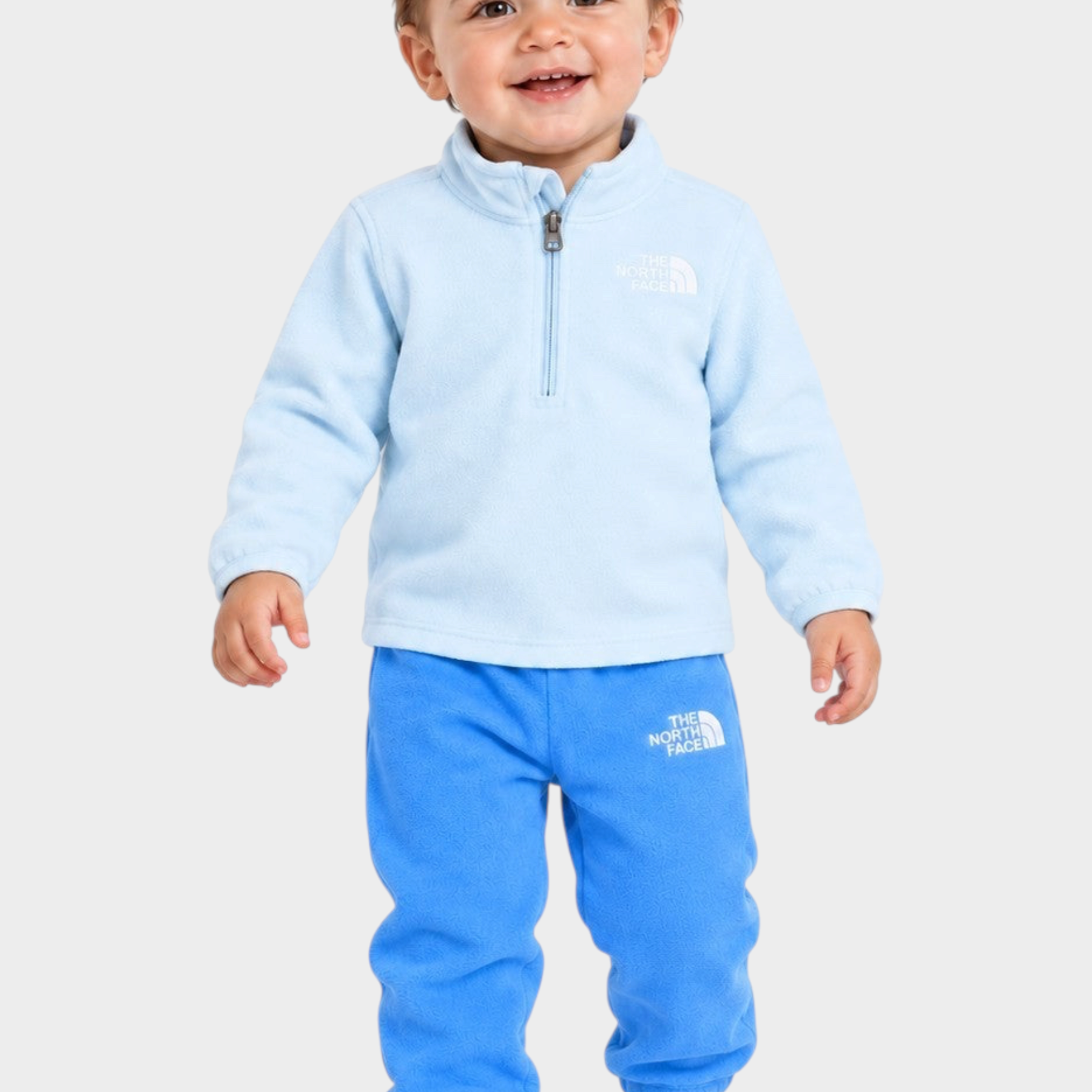 Bambino che indossa un completo due pezzi in pile azzurro Follower SRL con logo The North Face e zip frontale
