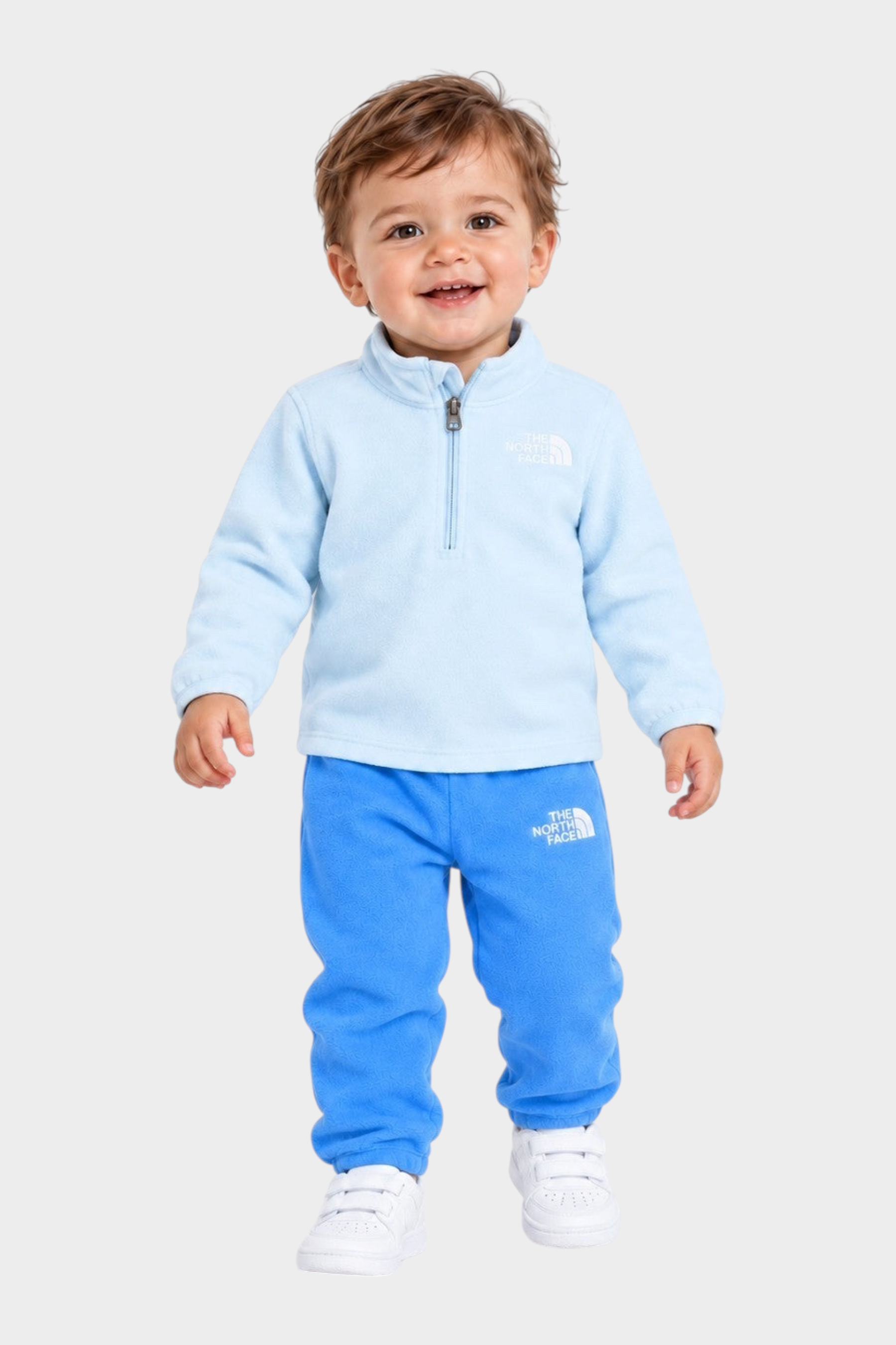 Bambino che indossa un completo due pezzi in pile azzurro Follower SRL con logo The North Face e zip frontale