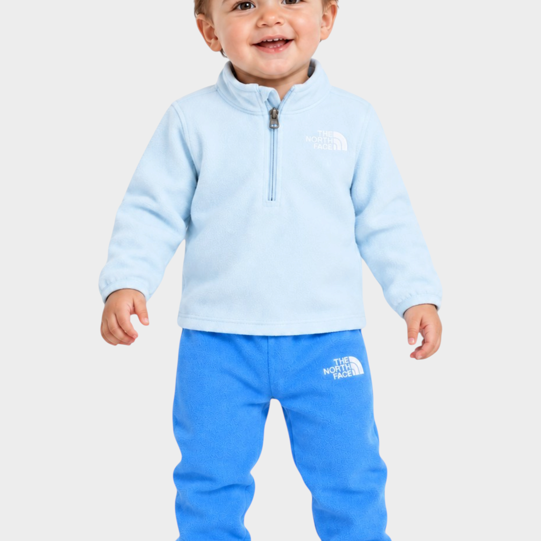 Bambino che indossa un completo due pezzi in pile azzurro Follower SRL con logo The North Face e zip frontale