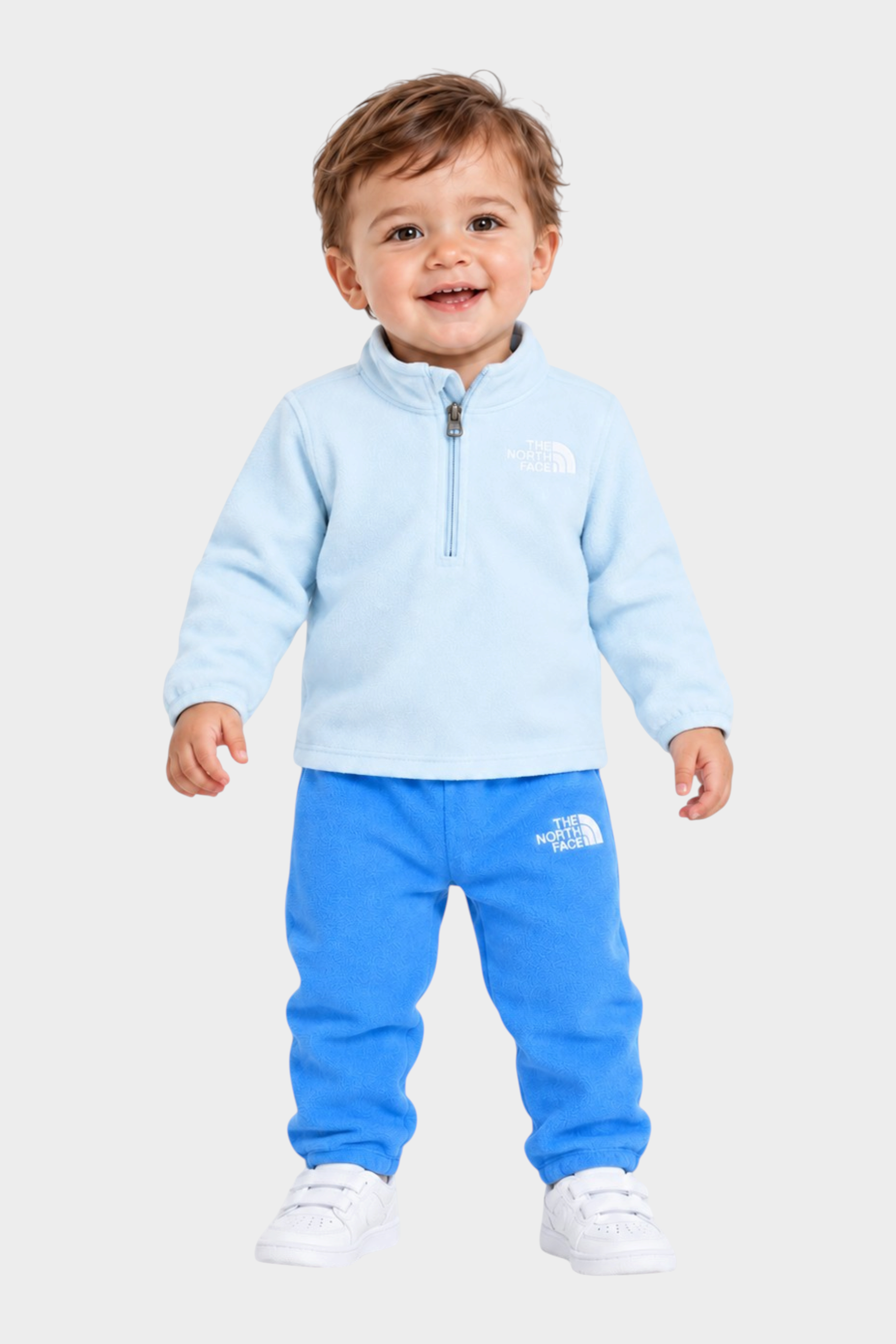 Bambino che indossa un completo due pezzi in pile azzurro Follower SRL con logo The North Face e zip frontale