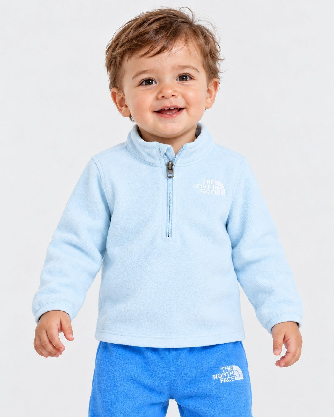 Bambino sorridente indossa completo due pezzi in pile azzurro Follower SRL Glacier di The North Face