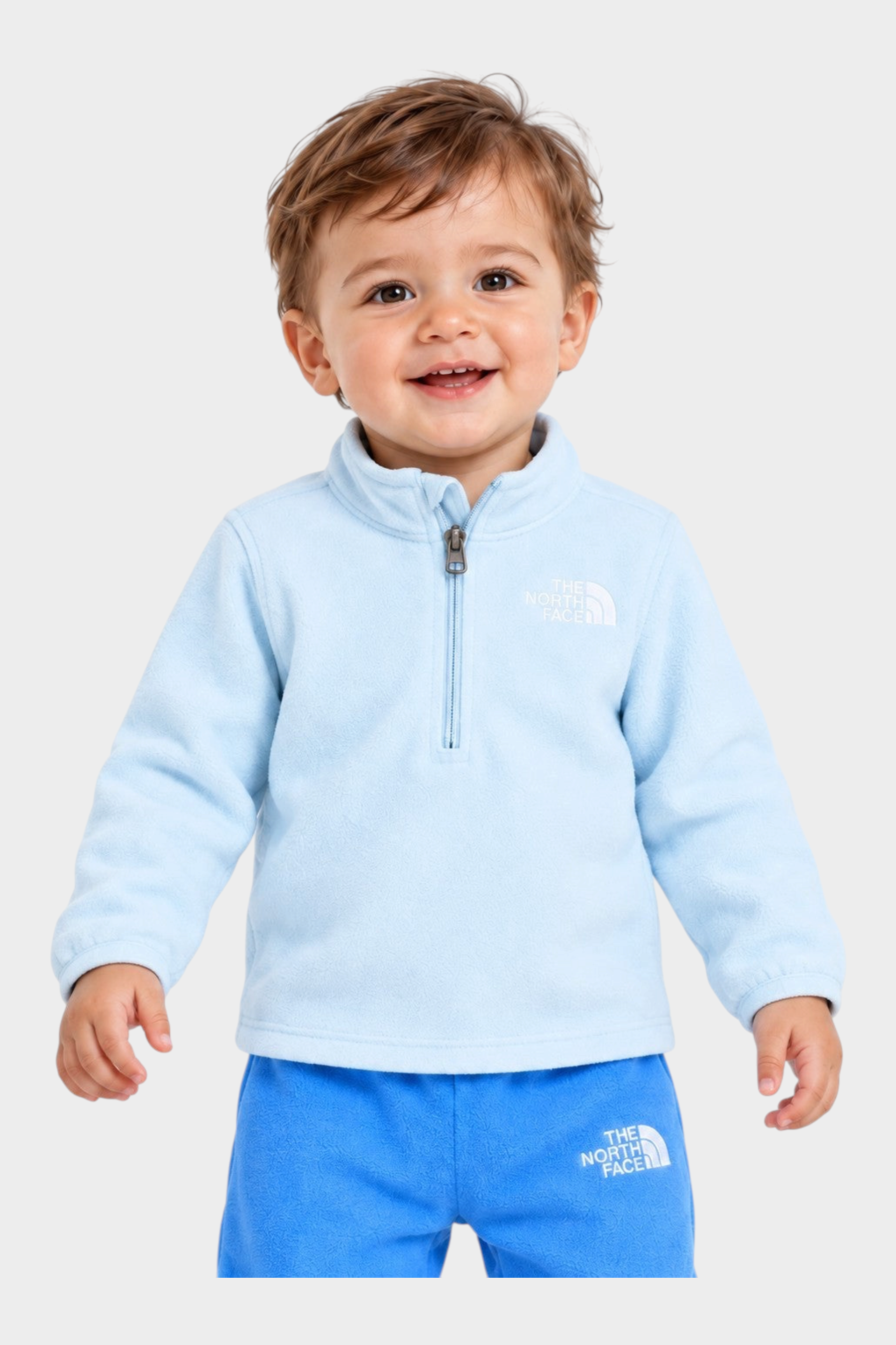 Bambino sorridente indossa completo due pezzi in pile azzurro Follower SRL Glacier di The North Face