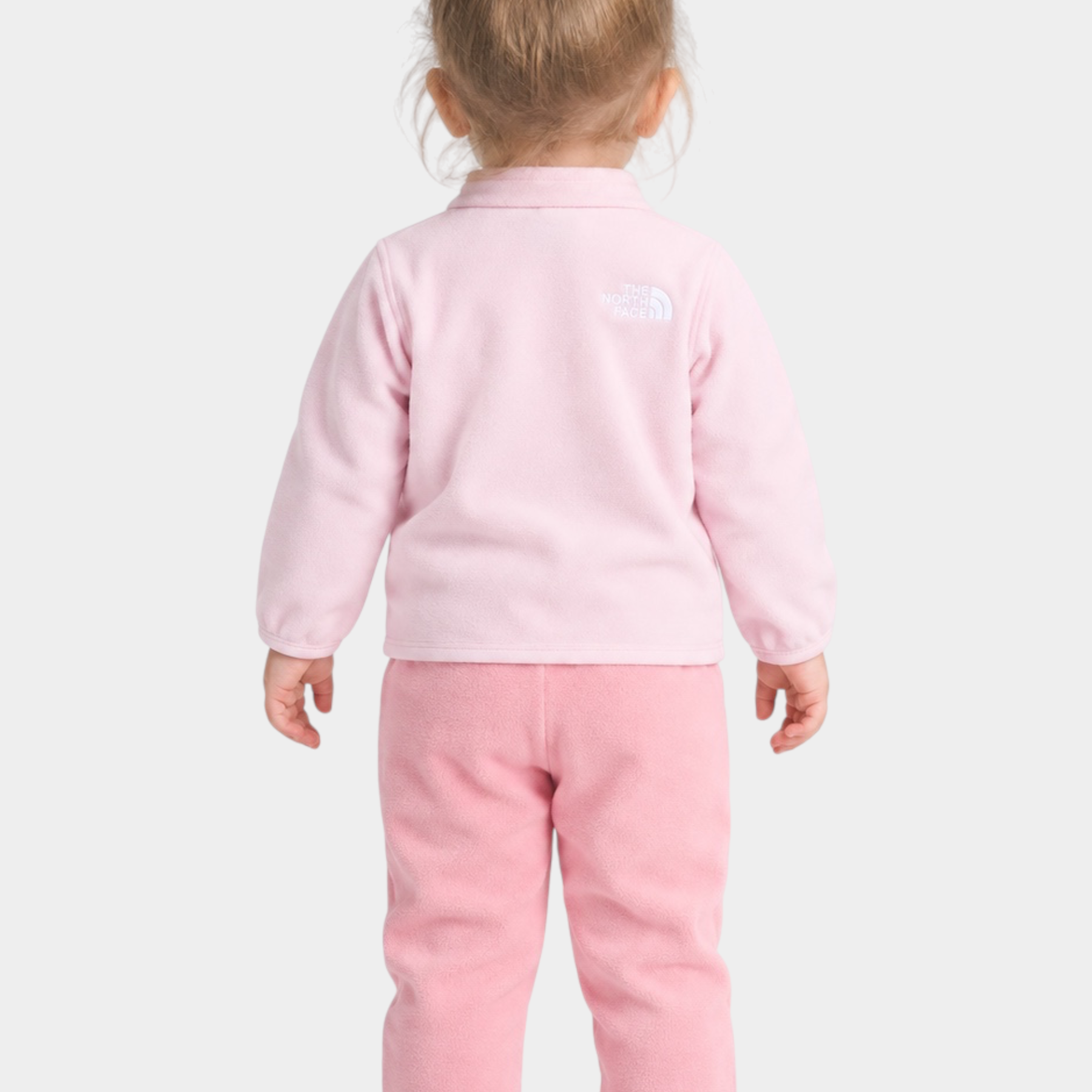 Bambina di spalle indossa un completo due pezzi in pile rosa Follower SRL The North Face con logo ricamato