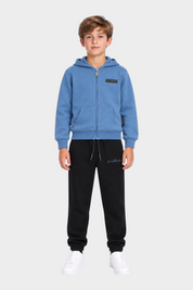 Ragazzo indossa completo sportivo Follower SRL azzurro con felpa con zip e pantaloni neri in cotone
