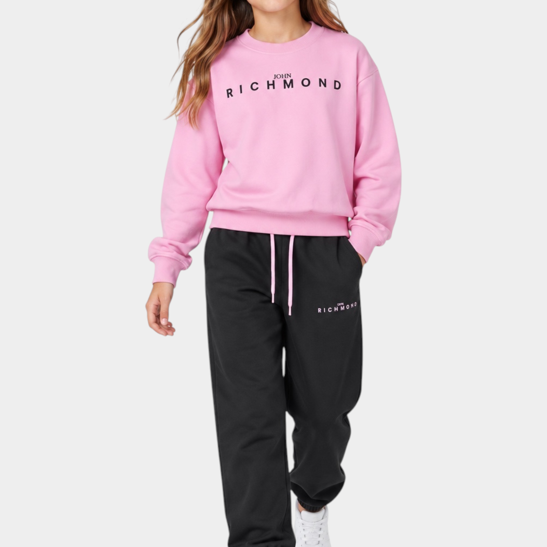 Ragazza indossa completo sportivo Follower SRL rosa e nero con felpa girocollo e pantaloni jogger logati