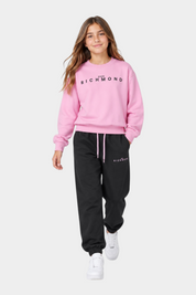 Ragazza indossa completo sportivo Follower SRL rosa e nero con felpa girocollo e pantaloni jogger logati
