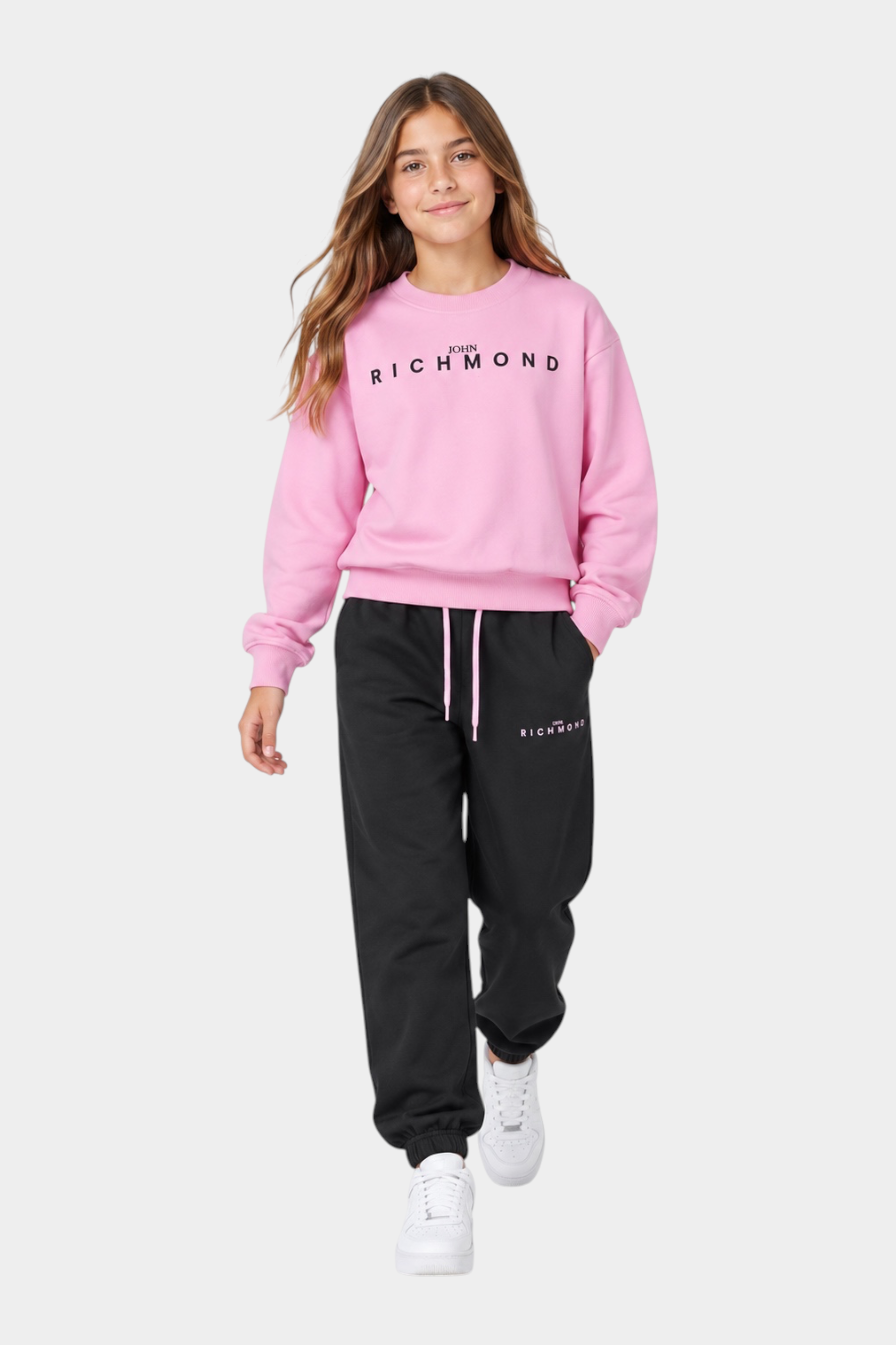 Ragazza indossa completo sportivo Follower SRL rosa e nero con felpa girocollo e pantaloni jogger logati