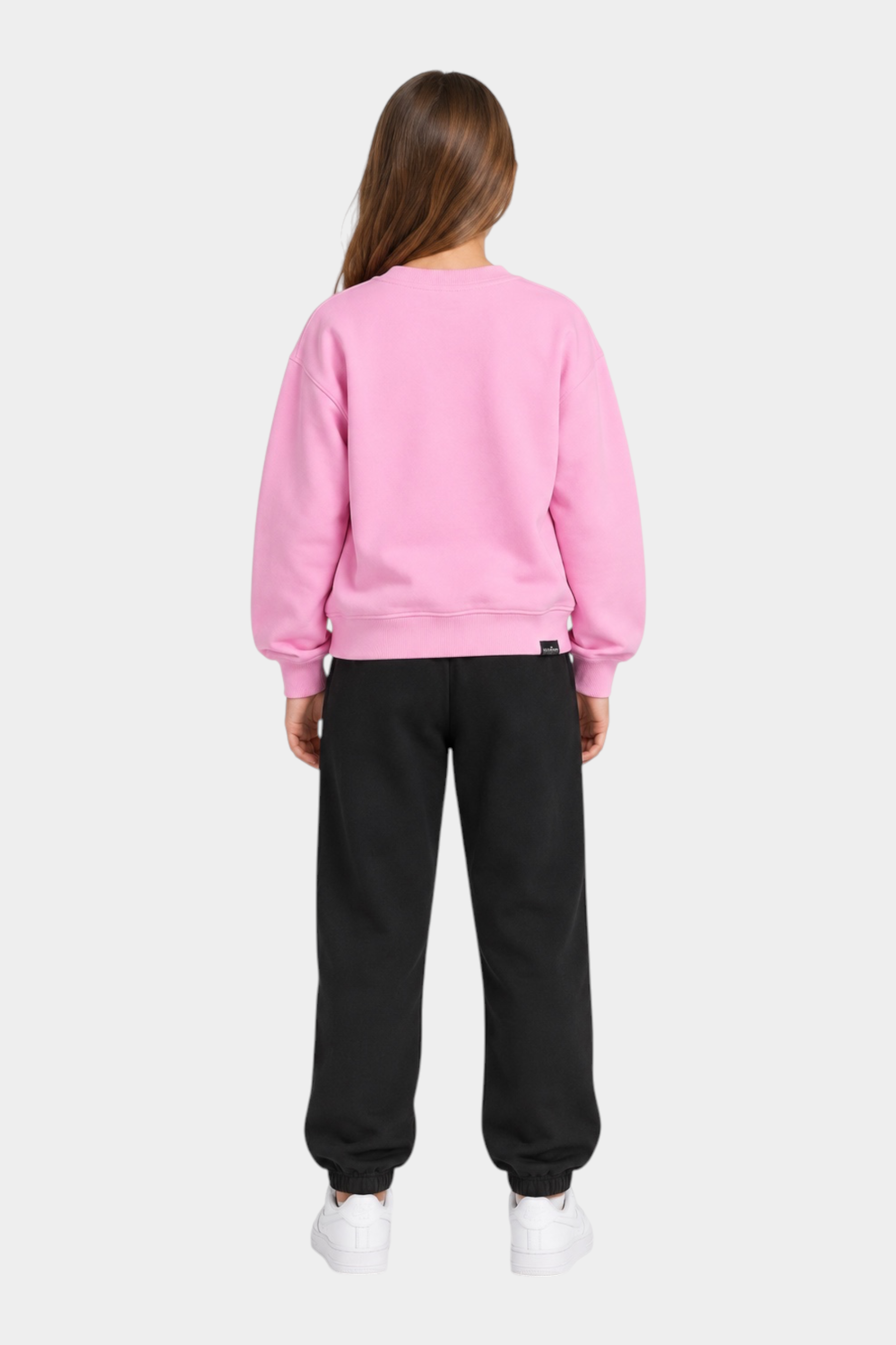 Ragazza indossa completo sportivo Follower SRL con felpa rosa girocollo e pantaloni neri in cotone
