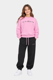 Ragazza indossa completo sportivo Follower SRL con felpa rosa e pantaloni neri con logo John Richmond
