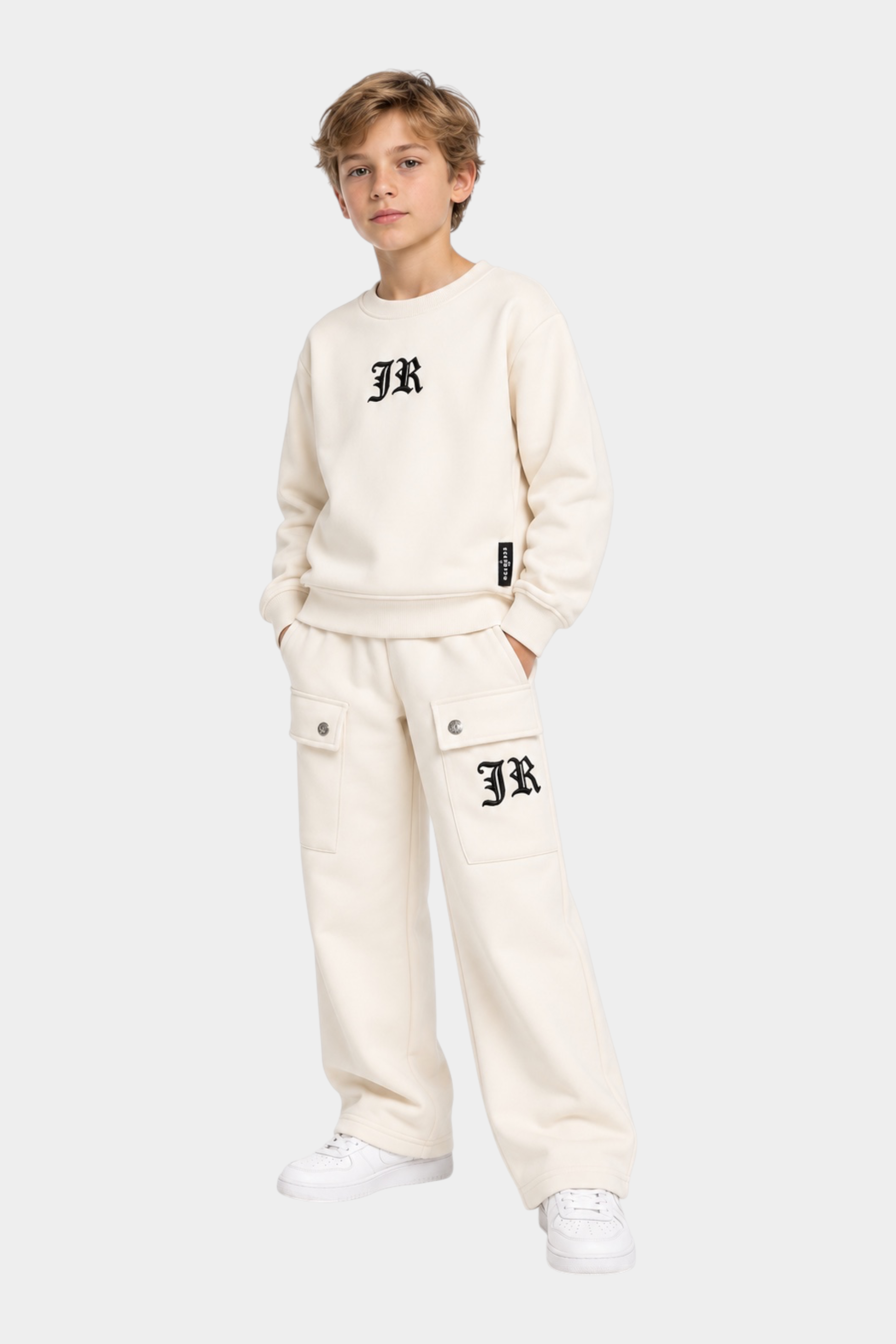 Ragazzo indossa un completo sportivo Follower SRL beige con felpa girocollo e pantaloni cargo con logo JR nero