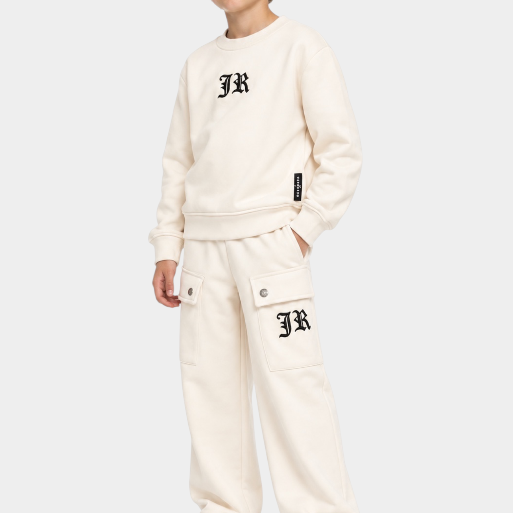 Ragazzo indossa completo sportivo Follower SRL beige con felpa girocollo e pantaloni cargo con logo JR nero