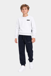 Ragazzo indossa completo sportivo Follower SRL con felpa bianca e pantaloni jogger blu scuro con logo RICHMOND