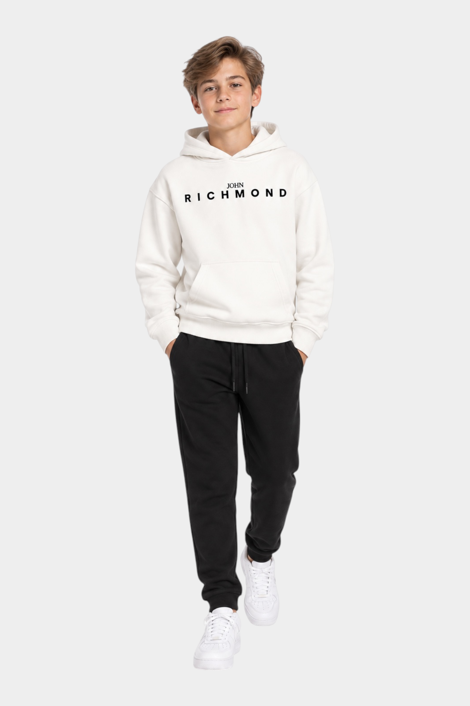 Ragazzo indossa completo sportivo Follower SRL con felpa bianca con logo RICHMOND e pantaloni neri