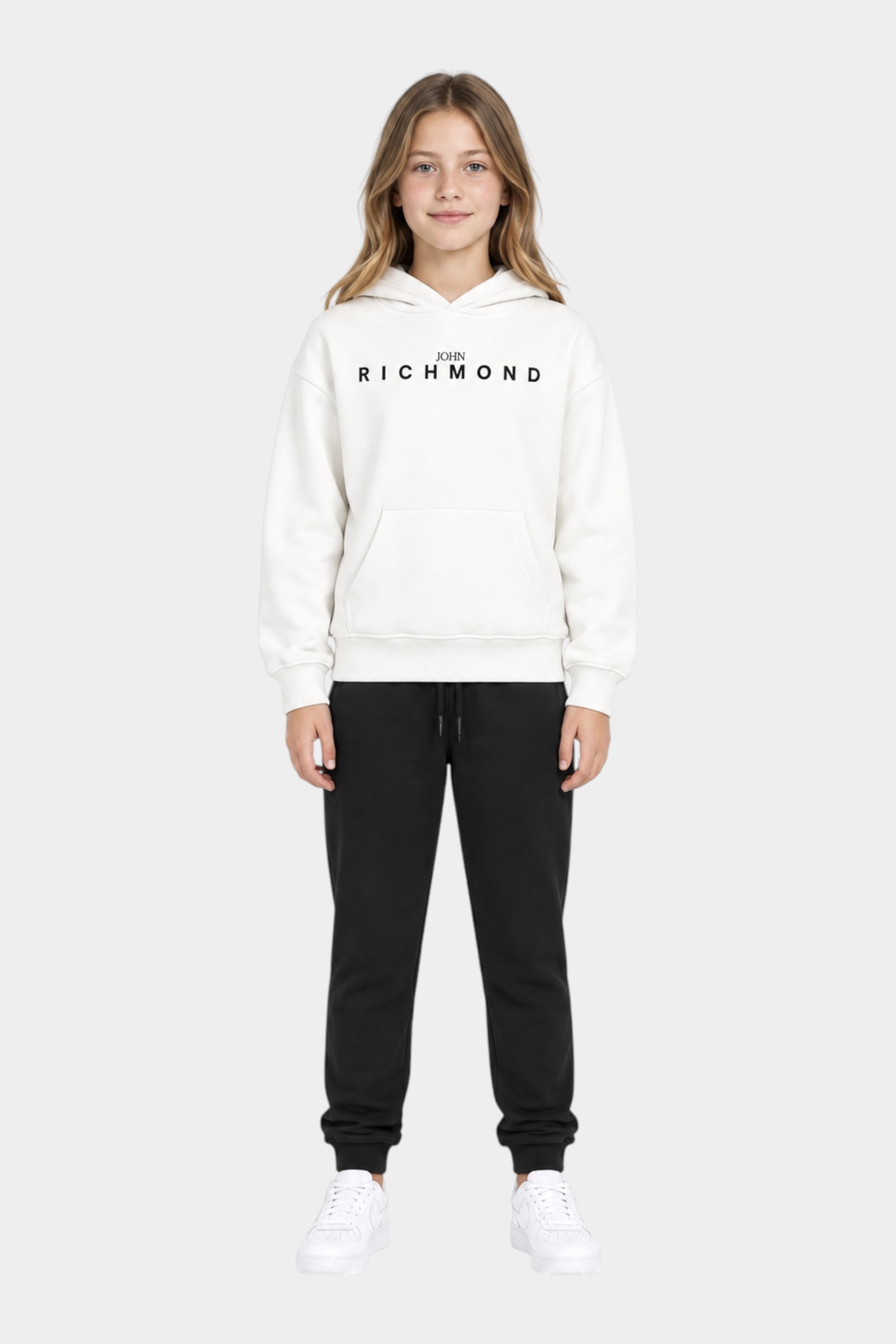 Ragazza indossa completo sportivo Follower SRL con felpa bianca con cappuccio e pantaloni neri