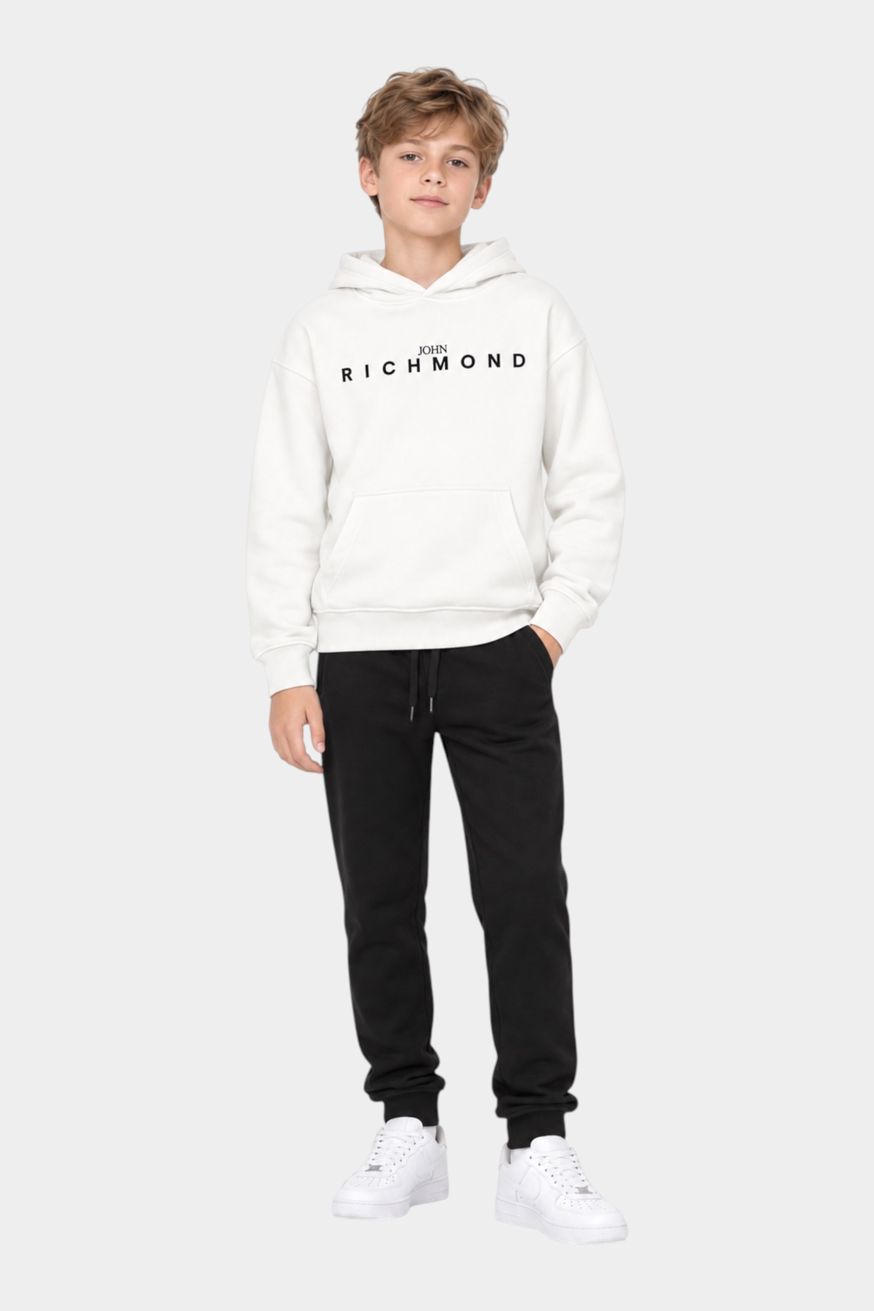 Ragazzo indossa completo sportivo Follower SRL con felpa bianca con cappuccio e logo RICHMOND e pantaloni neri