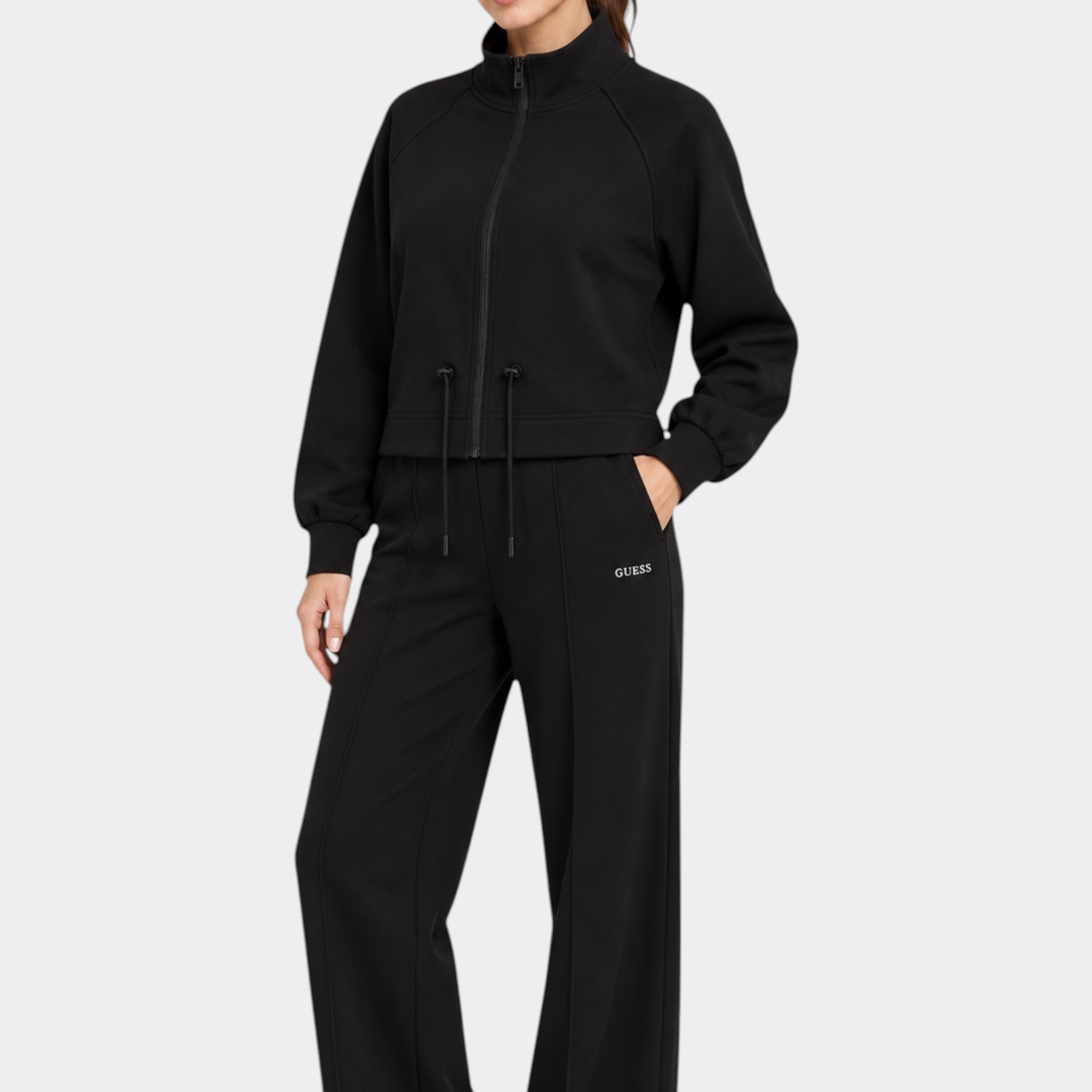 Modella indossa un completo sportivo nero Follower SRL composto da giacca con zip e pantaloni jogger a gamba larga