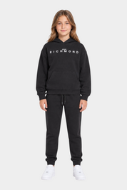 Ragazza che indossa un completo sportivo nero Follower SRL con felpa con cappuccio e logo RICHMOND bianco