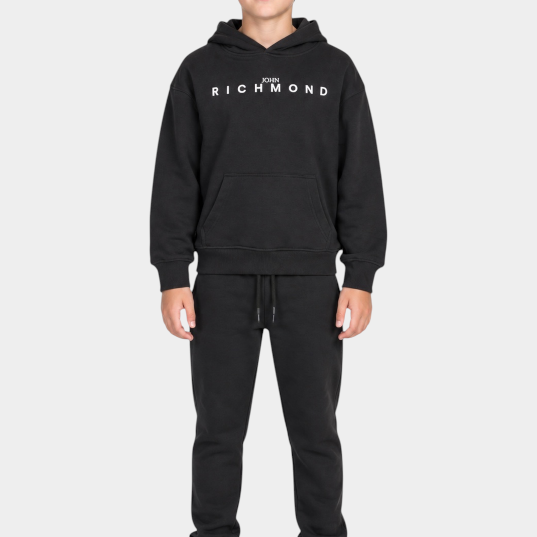 Ragazzo indossa un completo sportivo nero Follower SRL con felpa con cappuccio e logo John Richmond bianco