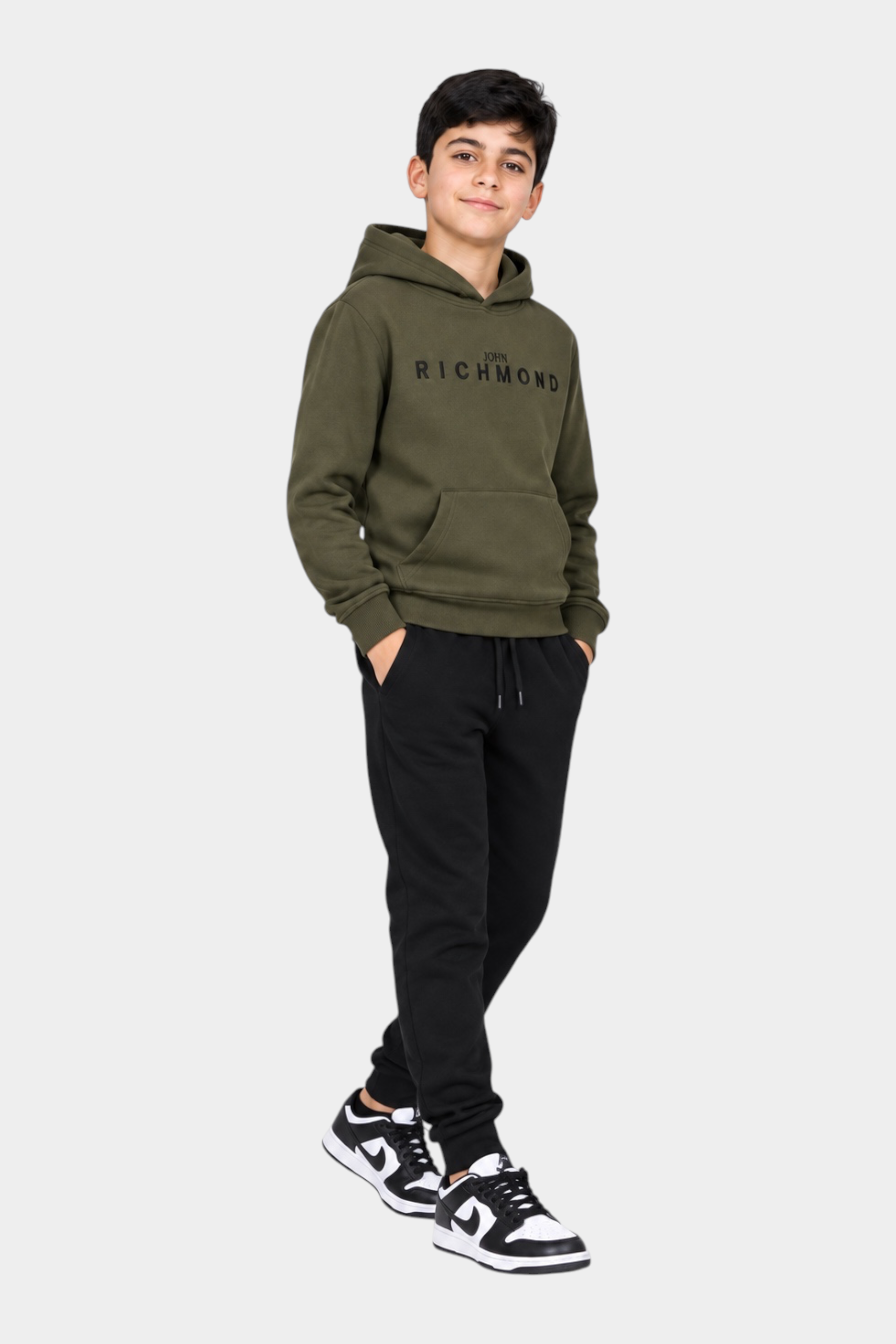 Ragazzo indossa completo sportivo Follower SRL con felpa verde con cappuccio Richmond e pantaloni neri