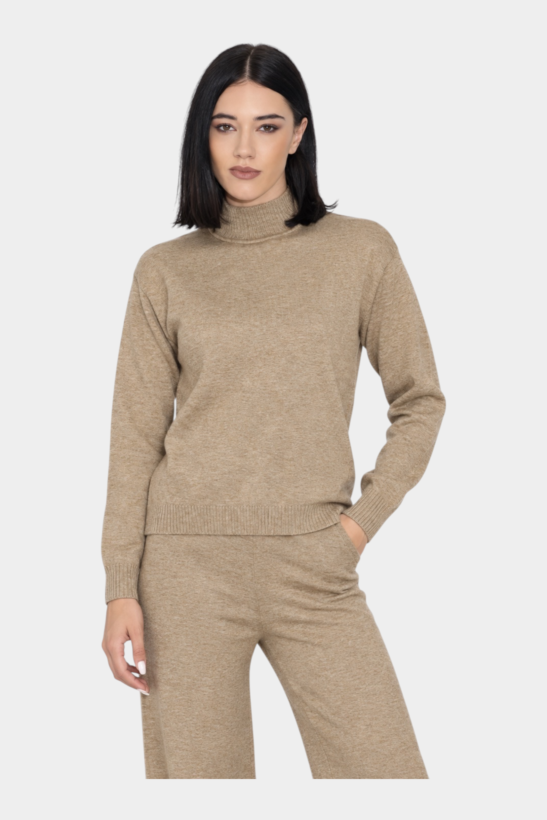 Modella indossa un dolcevita beige Follower SRL in maglia a collo alto, abbinato a pantaloni coordinati