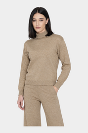 Modella indossa un dolcevita Follower SRL beige a maniche lunghe con collo alto in maglia morbida