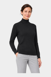 Donna che indossa un dolcevita nero in filo Ragno, elegante e aderente, ideale per un look casual chic.