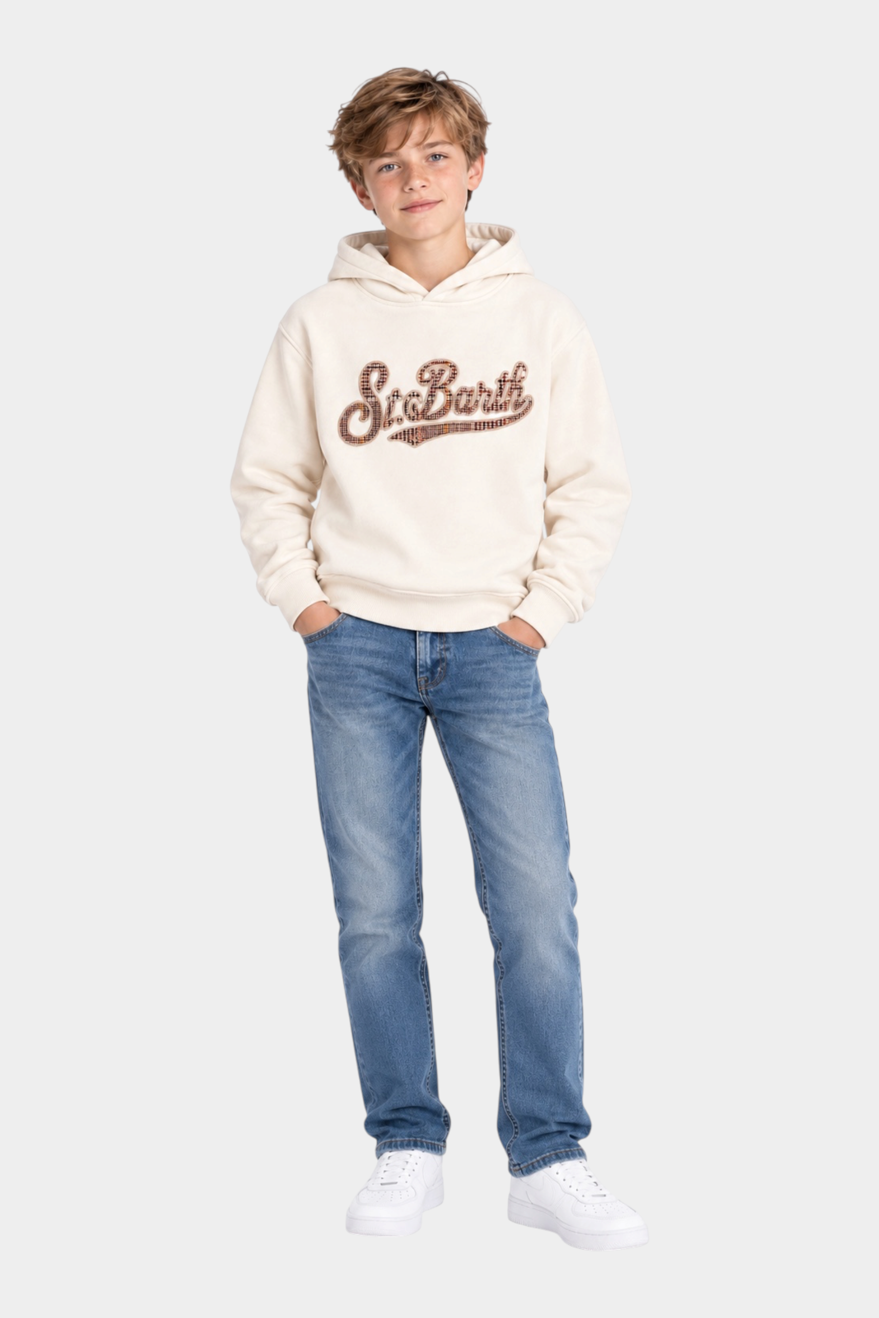 Ragazzo indossa felpa Follower SRL MC2 Saint Barth avorio con cappuccio e scritta tartan sul petto, jeans e sneakers