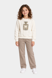Bambina indossa felpa Follower SRL bianca con stampa profumo gioiello e strass abbinata a pantaloni beige