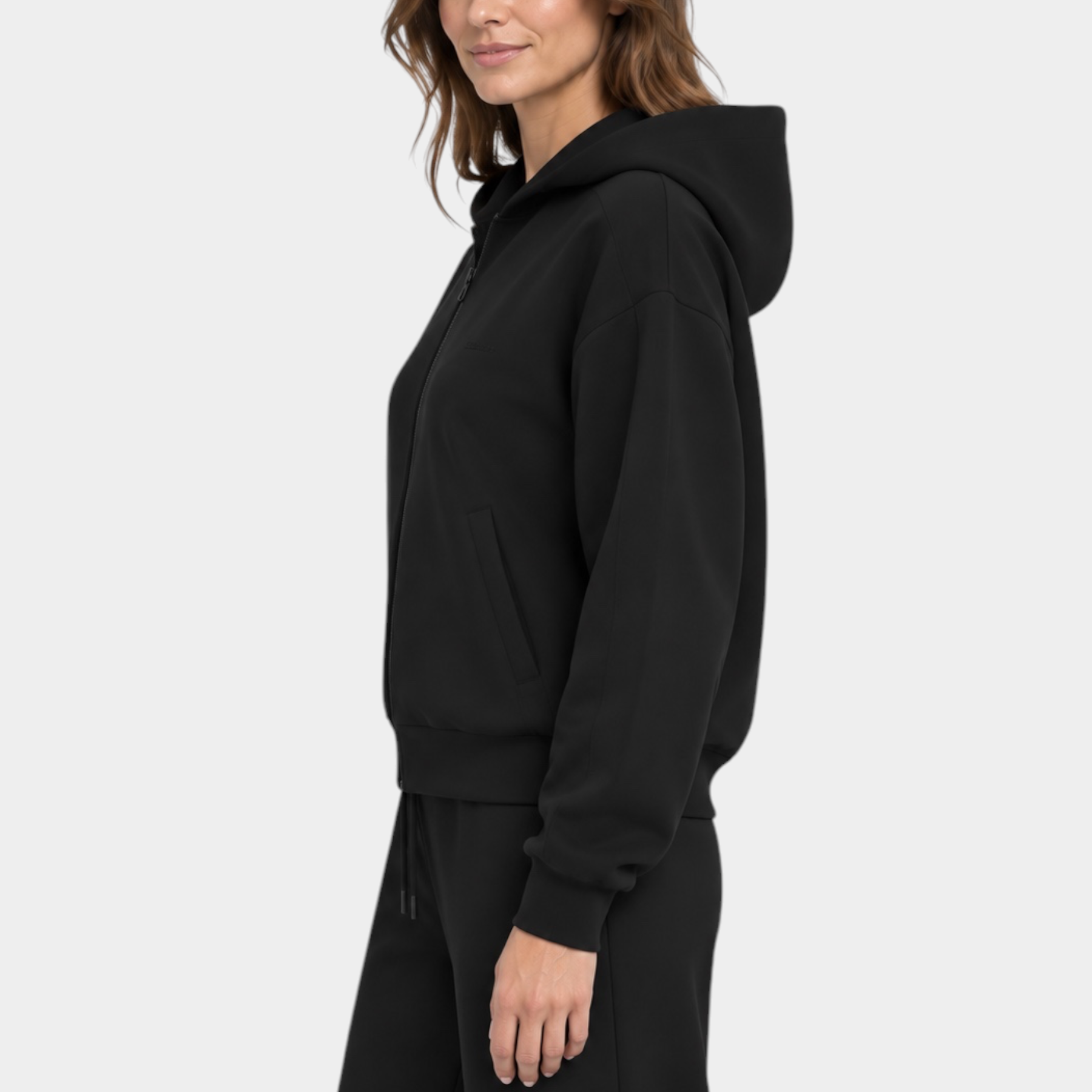 Modella indossa una felpa con cappuccio e zip intera nera di Follower SRL, vista laterale su sfondo bianco
