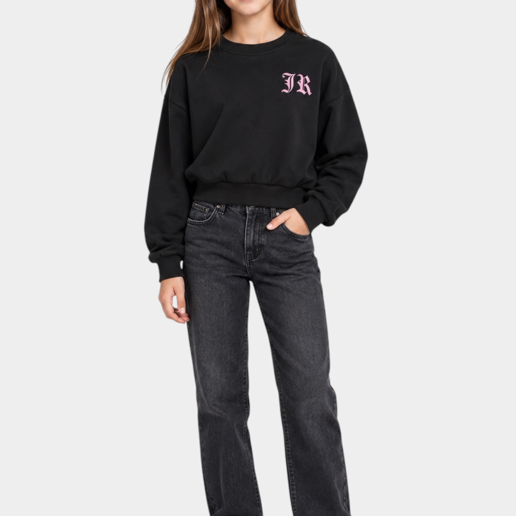 Ragazza indossa felpa girocollo nera Follower SRL con logo rosa, abbinata a jeans scuri e scarpe bianche