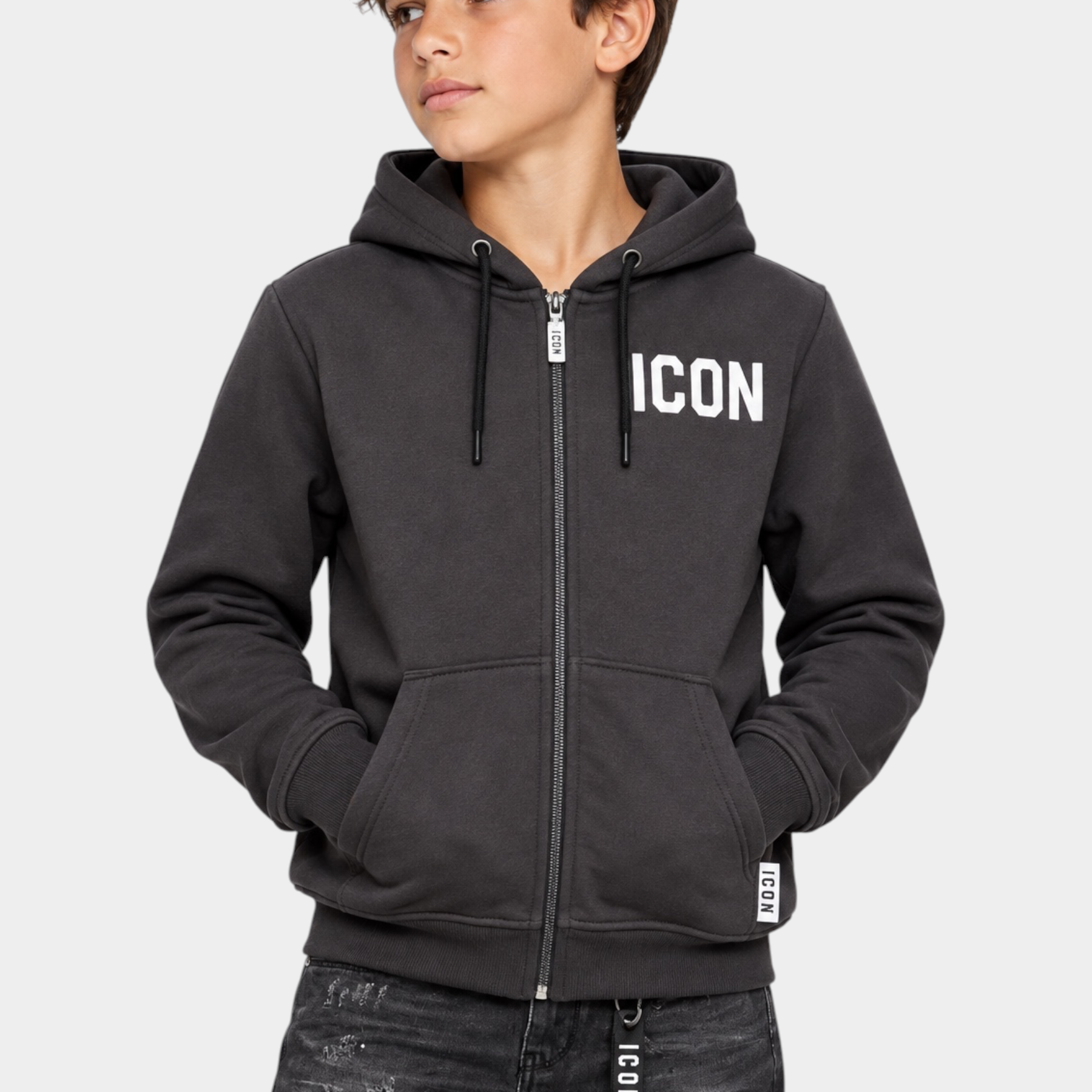 Ragazzo indossa una felpa Follower SRL grigia con zip integrale, cappuccio e scritta ICON bianca sul petto