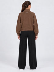 Felpa full zip marrone da donna GUESS vista posteriore indossata da una modella con pantaloni neri Follower SRL