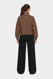 Felpa full zip marrone da donna GUESS vista posteriore indossata da una modella con pantaloni neri Follower SRL