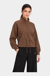 Felpa full zip marrone da donna GUESS indossata da una modella, con colletto alto e coulisse in vita Follower SRL