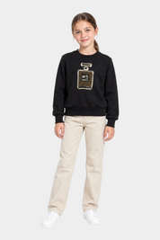 Bambina indossa felpa nera Follower SRL con decorazione gioiello a forma di profumo e strass, abbinata a pantaloni beige