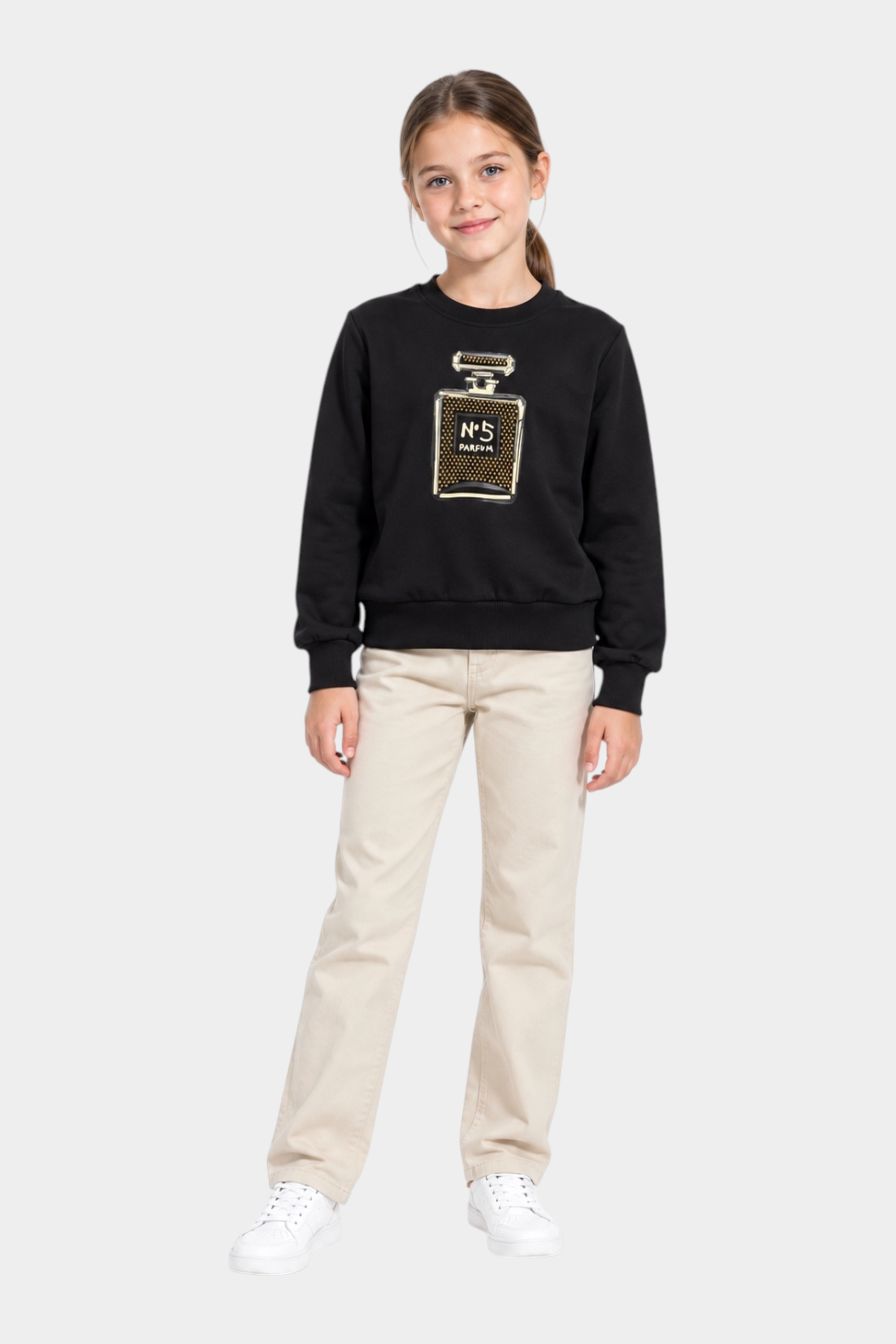 Bambina indossa felpa nera Follower SRL con decorazione gioiello a forma di profumo e strass, abbinata a pantaloni beige