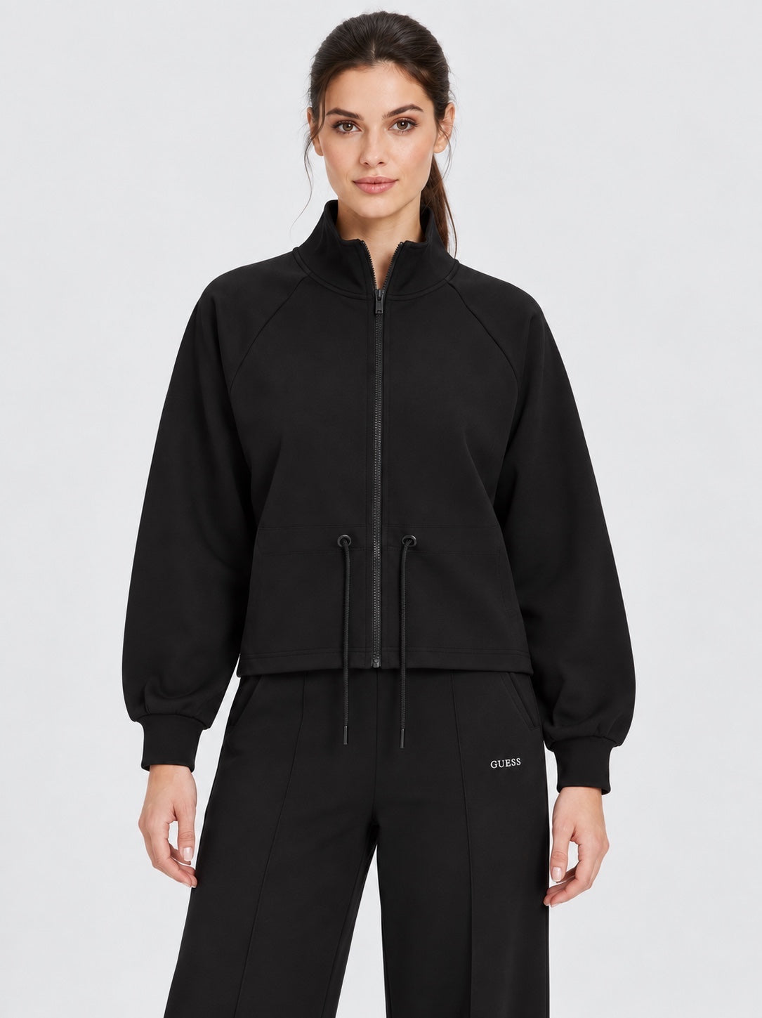 Modella indossa una felpa full zip nera Follower SRL con colletto alto e coulisse in vita, stile casual ed elegante